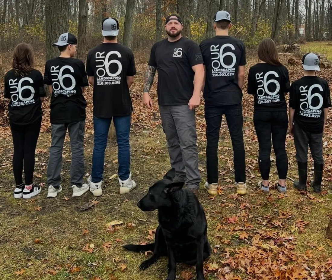The Our 6 crew in matching company shirts, family dog included