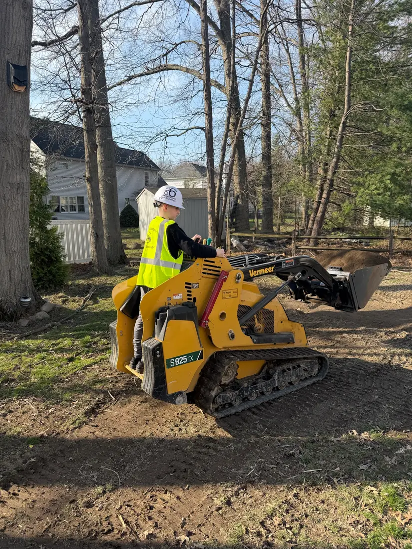 Mini skid steer working in the woods