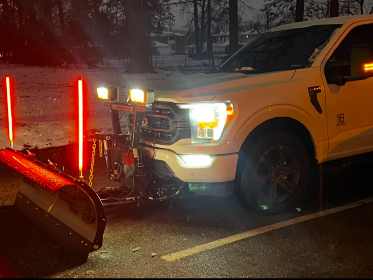 Our 6 plow truck with lit blade markers on a snowy residential street
